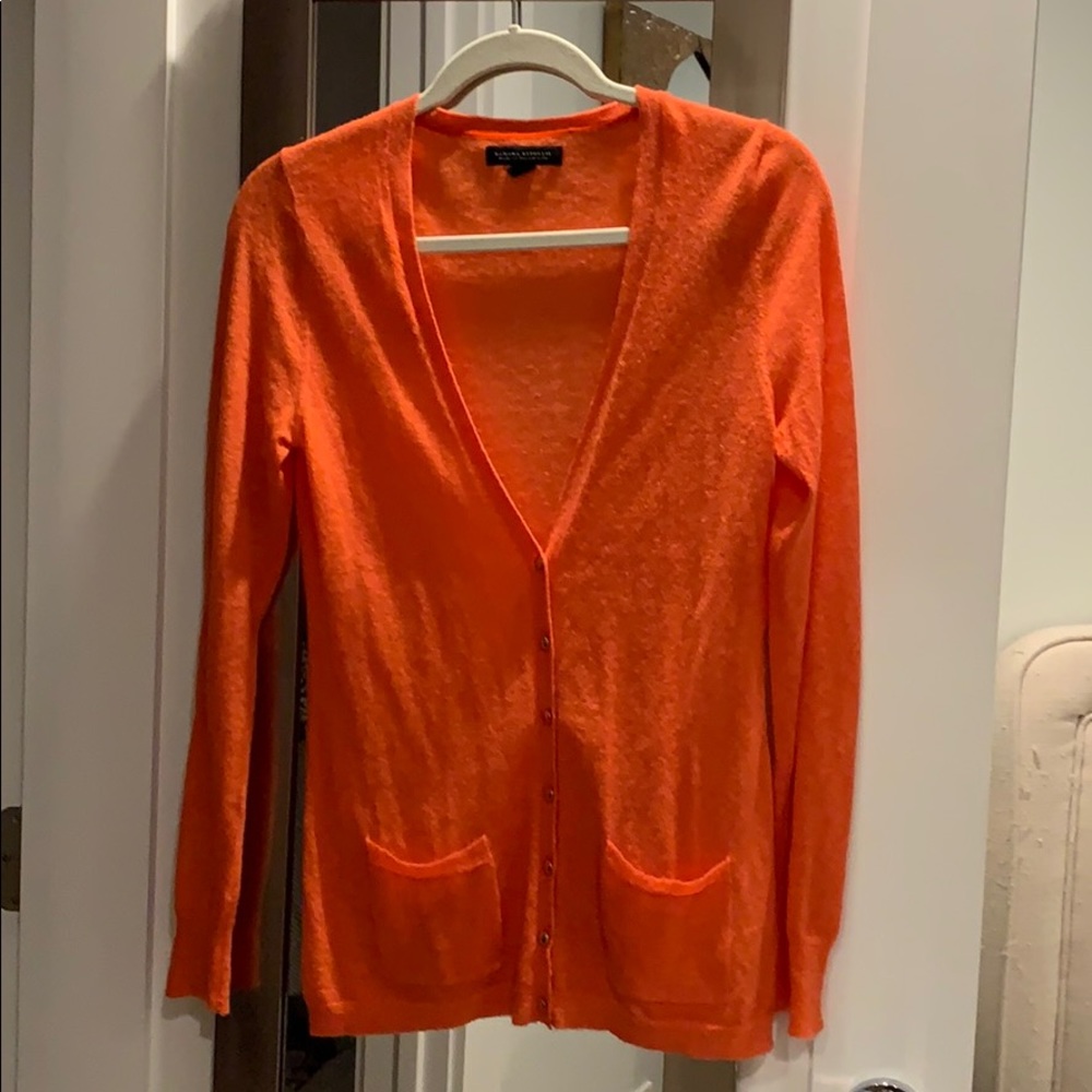 Salmon colored cardigan.